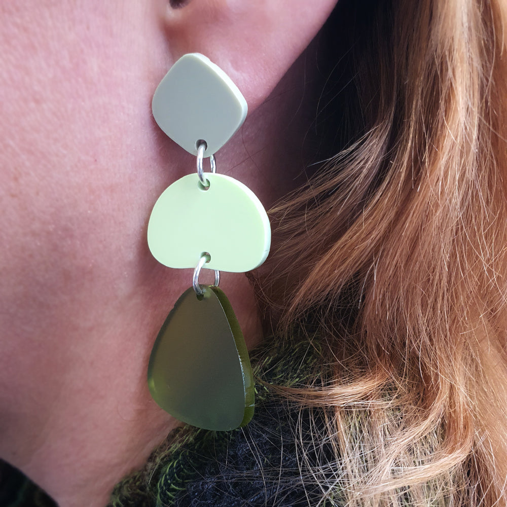 green pebble earring on ear
